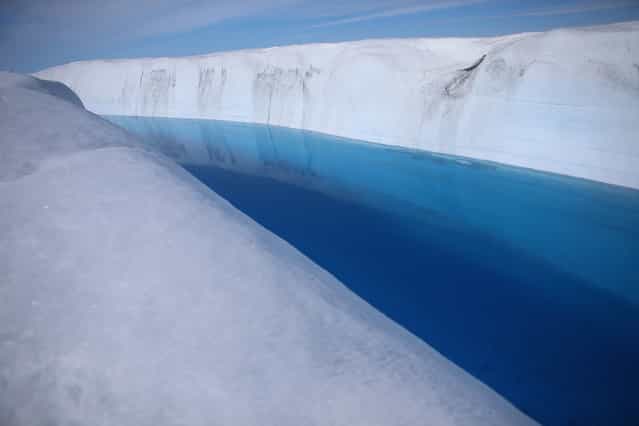 Meltwater stands on the surface of the glacial ice sheet, on July 17, 2013. (Photo by Joe Raedle/Getty Images via The Atlantic)