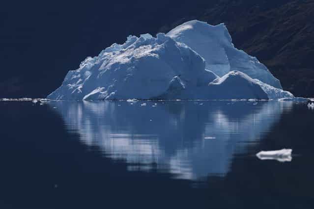 An iceberg floats through the water near Ilulissat, Greenland, on July 21, 2013. (Photo by Joe Raedle/Getty Images via The Atlantic)