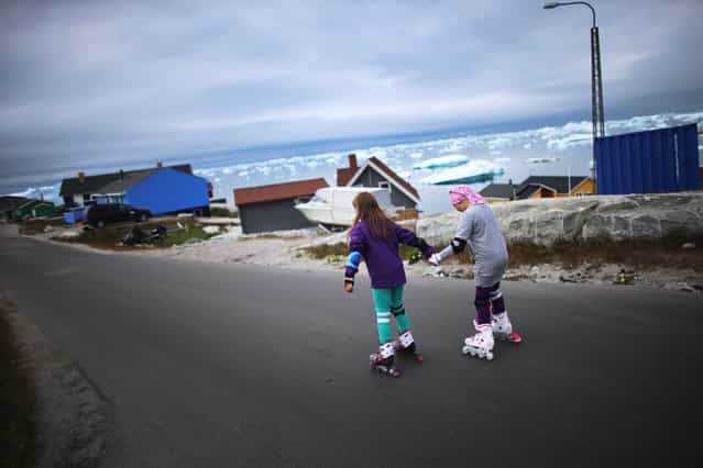 Youngsters rollerblade on an Ilulissat street in Greenland, on July 18, 2013. (Photo by Joe Raedle/Getty Images via The Atlantic)