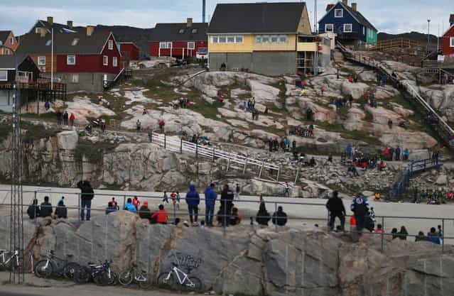 People watch as local soccer teams play on July 18, 2013 in Ilulissat, Greenland. As Greenlanders adapt to the changing climate and go on with their lives, researchers from the National Science Foundation and other organizations are studying the phenomena of the melting glaciers and its long-term ramifications for the rest of the world. (Photo by Joe Raedle/Getty Images via The Atlantic)