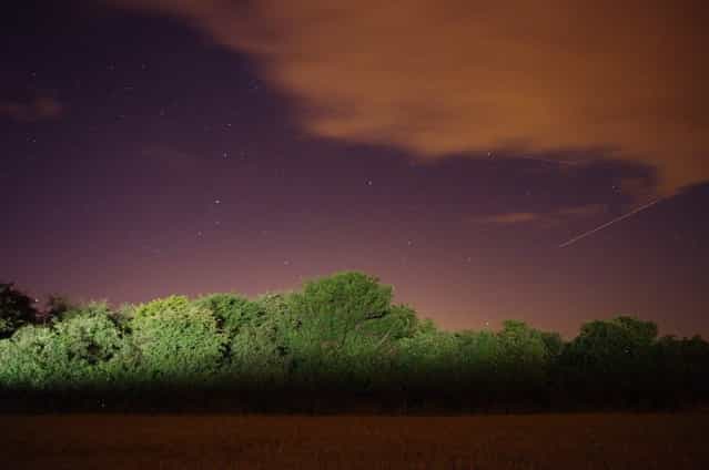 This photo was taken in August 2010 near Petersfield, England. Photographer pedrog78 said: [Love the colours in this one – the combo of the ever present light pollution and the trees painted by a passing car give the picture a surreal edge. I think I've got one meteor and one aircraft in this shot]. (Photo by pedrog78)