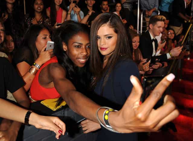 Selena Gomez poses with a fan at the MTV Video Music Awards on Sunday, August 25, 2013, at the Barclays Center in the Brooklyn borough of New York. (Photo by Scott Gries/AP Photo/Invision)