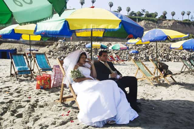 A bride and a groom rest before a ritual with shamans for Saint Valentine's Day at a beach in Lima Febraury 12, 2010. (Photo by Enrique Castro-Mendivil/Reuters)