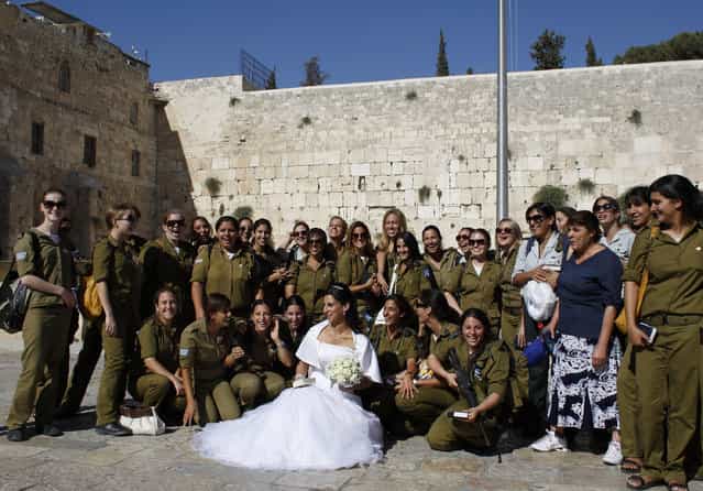 A bride poses for a photograph with Israeli soldiers at the Western Wall, Judaism's holiest prayer site, during a visit to Jerusalem's Old City June 23, 2009. (Photo by Darren Whiteside/Reuters)