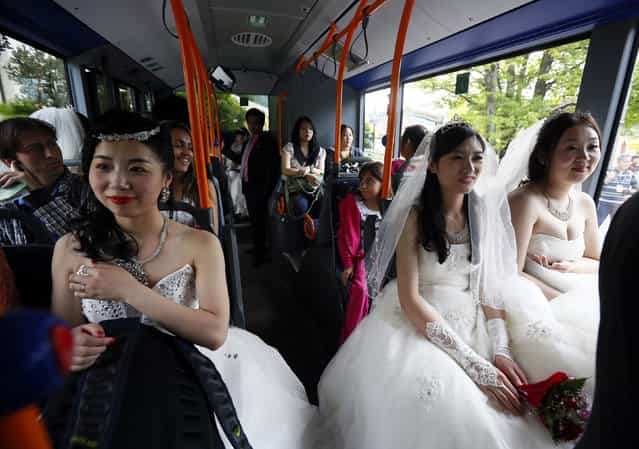 Chinese bridal couples travel on a public bus to the Neuschwanstein castle after their symbolic wedding in Fuessen May 31, 2012. Some 15 Chinese couples who already married in China, travelled to Germany to repeat their promise of marriage at Neuschwanstein Castle, one of the most popular destinations in Europe. (Photo by Michael Dalder/Reuters)
