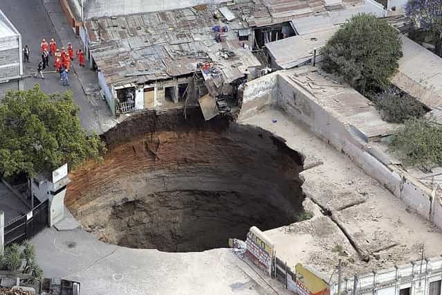 A giant sinkhole that swallowed several homes is seen in Guatemala City February 23, 2007. At least three people have been confirmed missing, officials said. (Photo by Reuters/Stringer)