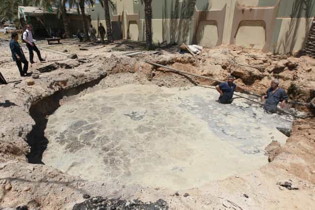 A crater, which the Libyan government said was caused by coalition air strikes, is seen at an area in Bab al-Aziziyah compound in Tripoli May 12, 2011. Libyan officials, who showed reporters around the scene of the air strike, at Gaddafi's Bab al-Aziziyah compound, said three people were killed and 25 wounded. (Photo by Louafi Larbi/Reuters)