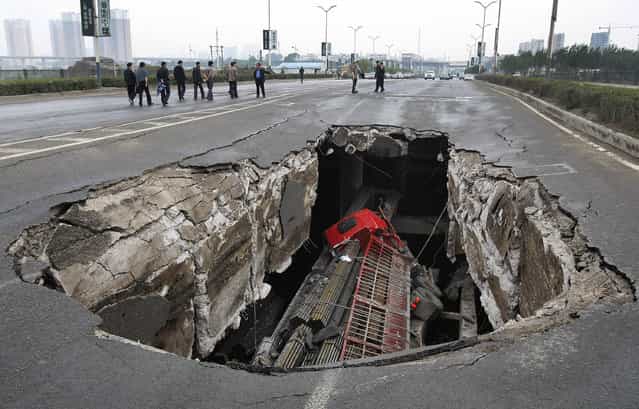A truck is seen in a hole after part of the structure of a bridge collapsed into a river in Changchun, Jilin province May 29, 2011. Two truck passengers were injured, while the cause of the accident is still under investigation, local media reported. (Photo by Reuters/China Daily)