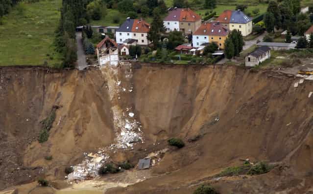 An aerial view shows the debris of a residential building and a destroyed road in the village of Nachterstedt, July 18, 2009. Three residents were missing in the eastern German village of Nachterstedt after their lakeside home and another building suddenly collapsed early Saturday into the water. A 350-metre stretch of shoreline gave way next to an old open-cast coalmine converted to a lake, about 170 kilometres south-west of Berlin. (Photo by Reuters/Gemeindeverwaltung Nachterstedt)
