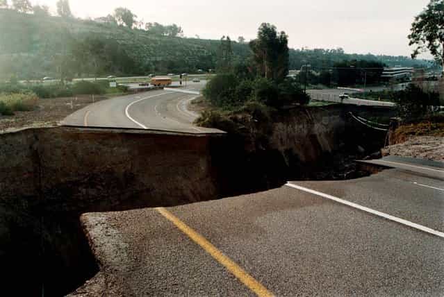 A sinkhole which damaged an on-ramp to Interstate 15 in San Diego on February 24 continues to grow February 25, 1998. The hole was caused by a drainage pipe which burst due to heavy rains attributed to El Nino weather patterns and is approximately eight hundred feet long, forty feet wide, and seventy feet deep. (Photo by Reuters)