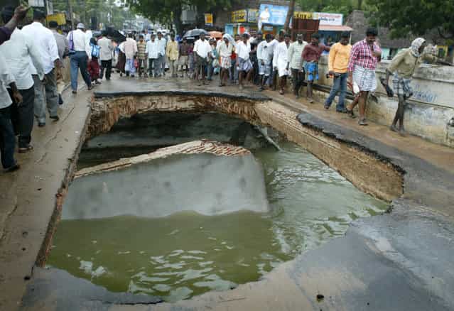 Indian local villagers walk on a bridge damaged by tsunami hit in Nagapattinam town, 350 km (219 miles) south of the southern Indian city of Madras, December 27, 2004. The death toll in a tidal wave triggered by an earthquake that slammed into coasts from India to Indonesia topped 22,000 on Monday as rescuers scoured the sea for missing tourists and soldiers raced to recover bodies amid growing fears of disease. (Photo by Punit Paranjpe/Reuters)