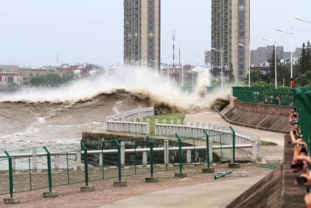 A tidal wave hits a bank along the Qiantang River on August 22, 2013 in Haining, China. The 12th typhoon Trami landed in Fujian province at 2:40 am and led gales and heavy rainfalls in east China. (Photo by ChinaFotoPress)