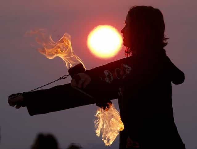 Krissy Humphreys performs with fire at sunrise at the Temple of Whollyness. (Photo by Jim Urquhart/Reuters)
