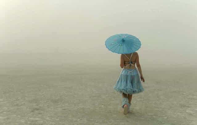 A young woman walks through the dusty playa. (Photo by Andy Barron/The Reno Gazette-Journal)
