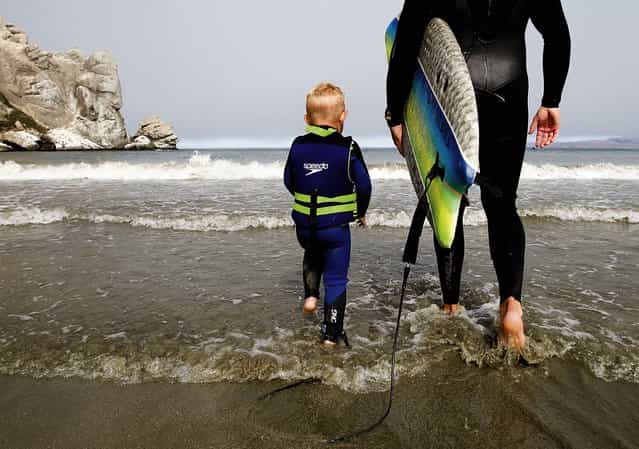 Triston and his father hit the waves. (Photo by Joe Johnston/The Tribune of San Luis Obispo)