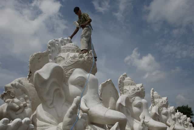 An Indian artist prepares idols of elephant-headed Hindu god Ganesh ahead of Ganesh Chaturthi festival at a workshop in Hyderabad, India, Monday, September 2, 2013. Ganesh Chaturthi, which begins from September 9, is celebrated as the birthday of Lord Ganesha who is widely worshiped by Hindus as the god of wisdom, prosperity and good fortune. (Photo by Mahesh Kumar A./AP Photo)