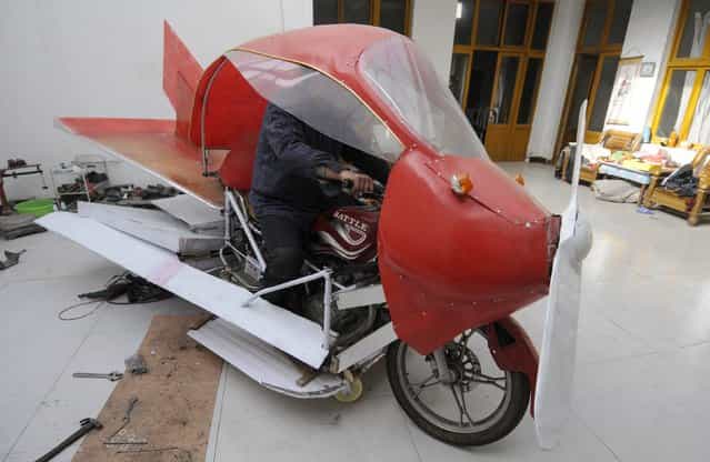 Zhang Xuelin sits inside his self-made aircraft at his home before its test flight in Jinan, Shandong province, November 28, 2012. Zhang, a farmer who dropped out of primary school in his early years, spent around 2,000 yuan ($321) to build a plane around a motorcycle, using wood and plastic boards. The plane, which took 11 months to build, failed in its test flight. (Photo by Reuters/China Daily)