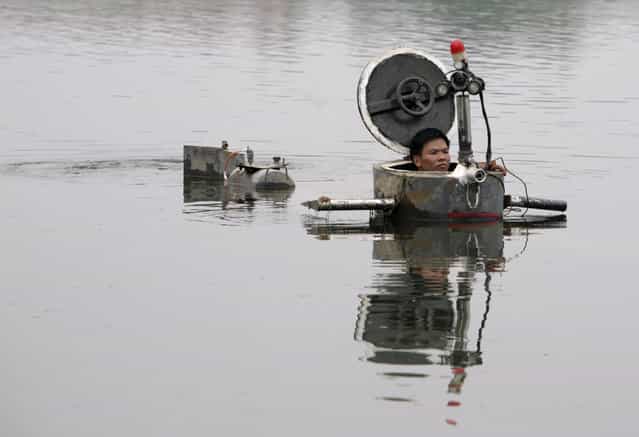 Amateur inventor Tao Xiangli operates his homemade submarine in a lake on the outskirts of Beijing September 3, 2009. Tao, 34, made a fully functional submarine, which has a periscope, depth control tanks, electric motors, manometer, and two propellers, from old oil barrels and tools which he bought at a second-hand market. He took 2 years to invent and test the submarine which costs 30,000 yuan ($4,385). (Photo by Christina Hu/Reuters)