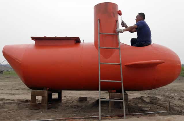 A worker paints a single-seater submarine designed by Zhang Wuyi and his fellow engineers at a shipyard in Wuhan, Hubei province May 7, 2012. Zhang, a 37-year-old local farmer, who is interested in scientific inventions, has made six miniature submarines with several fellow engineers, one of which was sold to a businessman in Dalian at a price of 100,000 yuan ($15,855) last October. The submarines, mainly designed for harvesting aquatic products, such as sea cucumber, have a diving depth of 20-30 metres, and can travel for 10 hours, local media reported. (Photo by Reuters/Stringer)