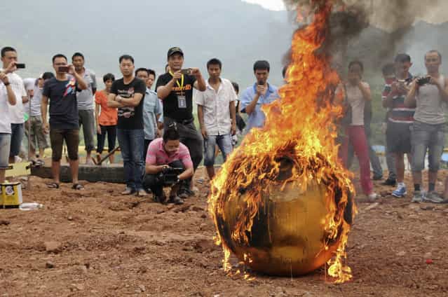 A smaller version of Noah's Ark of China, a six-ton (5,443 kg) ball container built by Chinese inventor Yang Zongfu, undergoes a burning test in Yiwu, Zhejiang province, August 6, 2012. According to local media, Yang spent two years and 1.5 million RMB (235,585 USD) to build the four-metre diameter vessel, which has been tested capable of housing a three-person family and sufficient food for them to live in 10 months. The vessel was designed to protect people inside from external heat, water and external impact. (Photo by Reuters/China Daily)