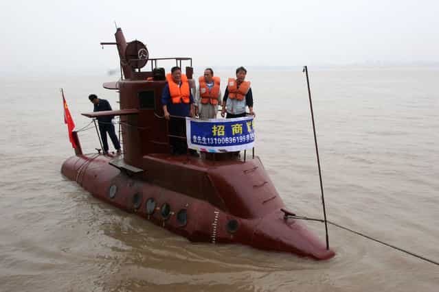 Chinese shipbuilders stand on a submarine designed by a farmer Li Yuming (not pictured) on the Yangtse River in Wuhan, central China's Hubei province in this picture taken September 24, 2005. The submarine, 9.8 meters long, two meters wide, and four meters high, was built by some ten shipbuilders in seven months. Maritime Administration of the Yangtse River banned the submarine's trial voyage because it did not undertake any navigational procedure. (Photo by Reuters/China NewsPhoto)
