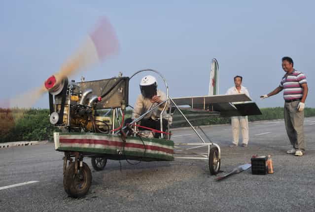 Ding Shilu (L) tests the engine of his home-made aircraft before conducting a test flight on the outskirts of Shenyang, Liaoning province, August 6. 2013. Ding, a 65-year-old migrant worker, spent around 2,000 yuan ($327) to build this 5-metre-long, 4.5-metre-high plane using components from motorcycles and electric bicycles. Ding failed his fourth test flight on Tuesday since he started his project four years ago, local media reported. (Photo by Sheng Li/Reuters)