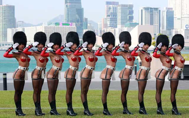 A line of [Crazy Horse] dancers in full regalia pose for photographers in Hong Kong, China, on September 11, 2012. (Photo by Ricky Ngan/AFP Photo/United Events)