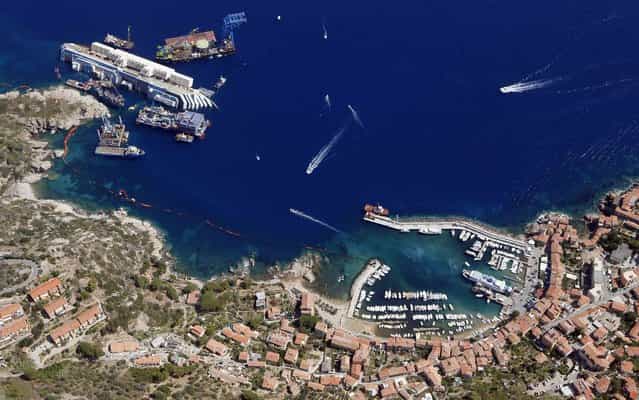 An aerial view shows the Costa Concordia as it lies on its side next to Giglio Island taken from an Italian navy helicopter, on September 12, 2013. (Photo by Alessandro Bianchi/Reuters)