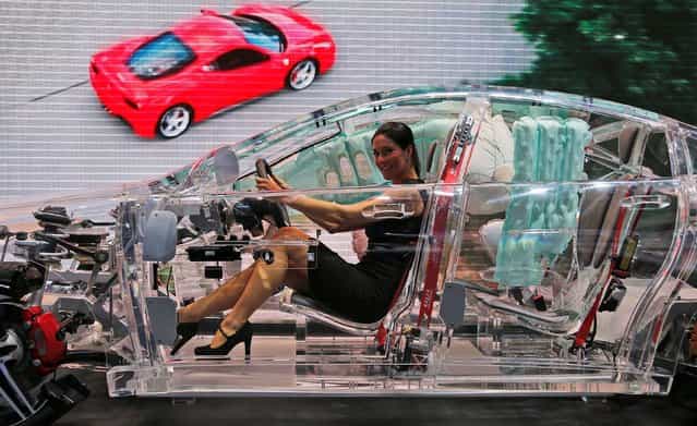 A woman sits in a car made of glass on display at the TRW booth, a worldwide leader in car protections systems, during the second press day of the 65th Frankfurt Auto Show in Frankfurt, Germany, Wednesday, September 11, 2013. More than 1,000 exhibitors will show their products to the public from September 12 through September 22, 2013. (Photo by Frank Augstein/AP Photo)
