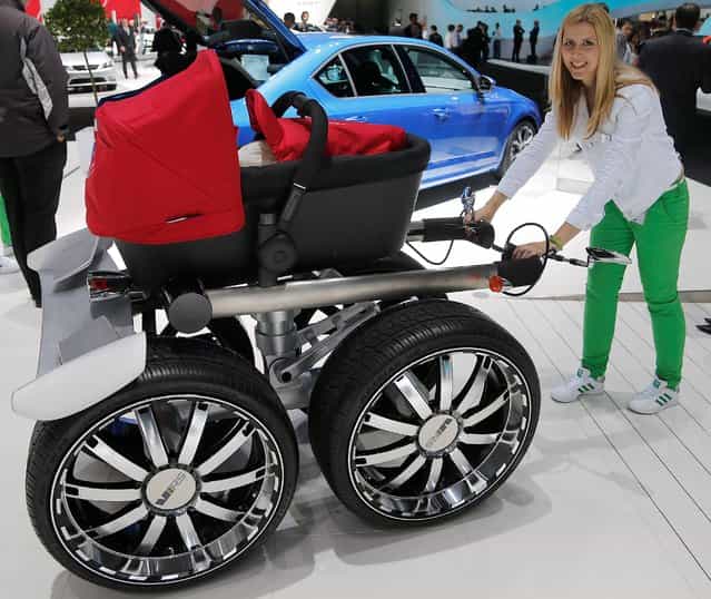 A baby carriage with car wheels is pictured at the Skoda car booth as an advertising during the second press day of the 65th Frankfurt Auto Show in Frankfurt, Germany, Wednesday, September 11, 2013. (Photo by Frank Augstein/AP Photo)