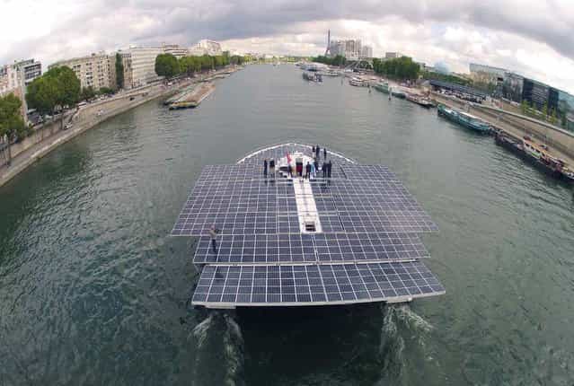 The Turanor PlanetSolar, the world's largest solar-powered boat, travels on the Seine river next to the Eiffel tower in Paris September 10, 2013. PlanetSolar, a catamaran powered exclusively by solar energy, completed the first solar-powered trip around the world on May 4, 2012 after travelling over 60,000 km (37,282 miles) in 584 days. (Photo by Charles Platiau/Reuters)
