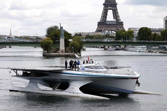 The Turanor PlanetSolar, the world's largest solar-powered boat, travels on the Seine river next to the Eiffel tower in Paris September 10, 2013. PlanetSolar, a catamaran powered exclusively by solar energy, completed the first solar-powered trip around the world on May 4, 2012 after travelling over 60,000 km (37,282 miles) in 584 days. (Photo by Charles Platiau/Reuters)