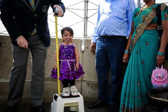Jyoti Amge, from Nagpur, India, is measured by a Guinness World Record official on the observation deck of the Empire State Building, on September 12, 2013. Standing 24.7 inches (62.7 cm) tall, Amge has held the title of the [Shortest Living Woman] since her 18th birthday on December 16, 2011. (Photo by Shannon Stapleton/Reuters)