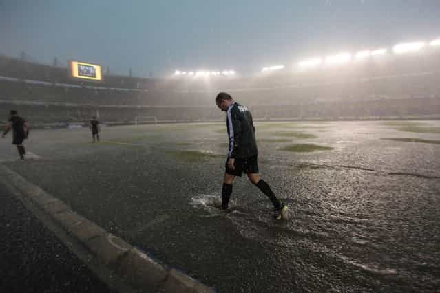 A FIFA referee checks the field during a downpour before the start of the 2014 World Cup qualifying soccer match between Colombia and Ecuador in Barranquilla, on September 7, 2013. (Photo by John Vizcaino/Reuters)