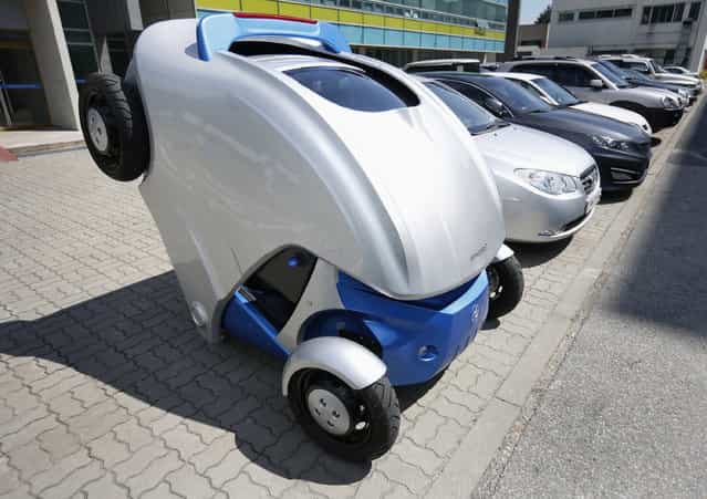 Armadillo-T, a foldable electric vehicle, folds up its rear at the Korea Advanced Institute of Science and Technology (KAIST) in Daejeon, south of Seoul September 2, 2013.With a click on a smartphone, the experimental [Armadillo-T] electric car made in South Korea will park itself and fold nearly in half, freeing up space in crowded cities. The quirky two-seater, named after the animal whose shell it resembles, may never see production but it is part of a trend of developing environmentally friendly vehicles for urban spaces. Picture taken September 2, 2013. (Photo by Kim Hong-Ji/Reuters)
