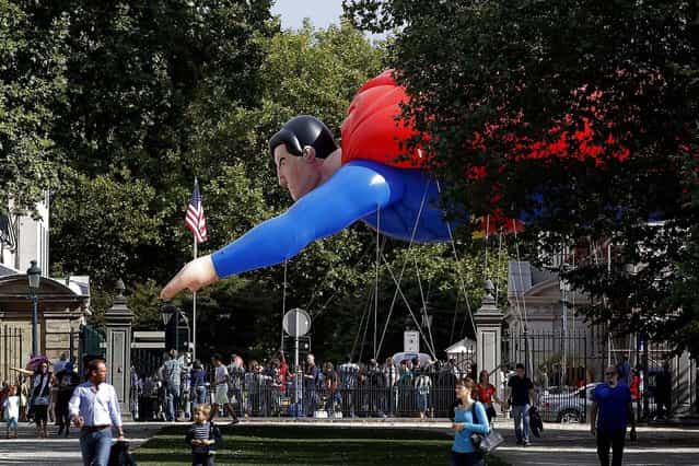 A giant inflatable Superman flies past the U.S. embassy during the Balloon Day Parade in Brussels, on September 7, 2013. Giant figures representing well-known comic strips and Belgian characters are parading as part of the [Comic Strip Festival]. (Photo by Yves Logghe/Associated Press)