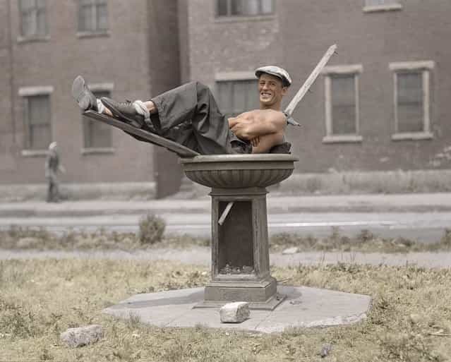 Man cooling off in bird bath on hot day, Boston, c.1930s.