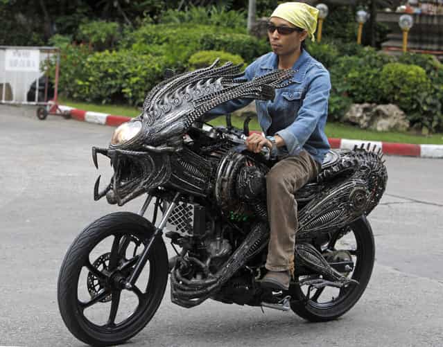 A worker drives a motorcycle made from recycled materials of spare parts from cars and bicycles at a workshop owned by Roongrojna Sangwongprisarn in Bangkok July 27, 2011. Roongrojna, 54, creates his artworks from recycled spare parts from used cars, motorcycles as well as bicycles. With four shops in Bangkok named [Ko Art Shop], Roongrojna also exports his artworks to clients all over the world. (Photo by Sukree Sukplang/Reuters)