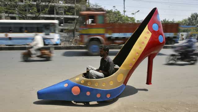 A worker test drives a car in the shape of a heels on a road in the southern Indian city of Hyderabad March 7, 2012. The shoe is part of a ladies series of creations by Indian car designer Sudhakar Yadav to mark the International Women's Day and the car can run at a maximum speed of 45 kph (28 mph). (Photo by Krishnendu Halder/Reuters)