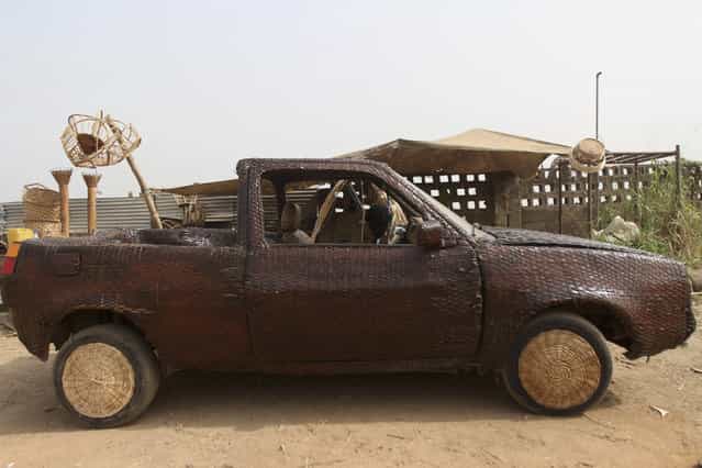 A converted car, which is covered with woven raffia palm cane, is parked in front of an artisan workshop in Ibadan, southwest Nigeria January 10, 2013. (Photo by Akintunde Akinleye/Reuters)