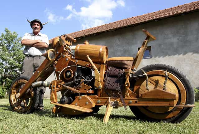 Hungarian Istvan Puskas poses with his wooden chopper in Tiszaors, 161km (100 miles) east of Budapest, June 14, 2012. Puskas, a 52-year-old tractor driver, built his bike in two years from firewood. (Photo by Laszlo Balogh/Reuters)