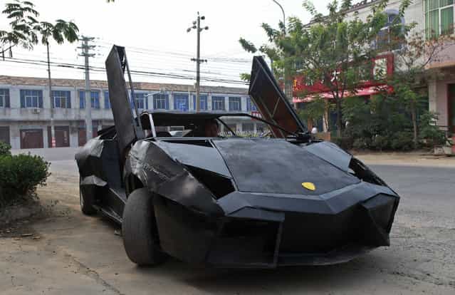 A friend of Wang Jian sits in a hand-made replica of a Lamborghini Reventon in Suqian, Jiangsu province August 30, 2012. Wang, a young Chinese farmer who worked at a garage for more than a decade, built the replica of a Lamborghini Reventon with a second-hand Nissan and Santana. The self-made roadster cost Wang around 60,000 RMB ($9,450) and can reach a maximum speed of 160mph, according to local media reports. (Photo by Reuters/Xihao)