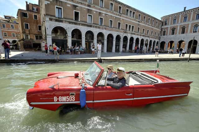 Bernd Weise, of the Amphicar Club Berlin, pilots his 1961 Amphicar down the Grand Canal in Venice May 28, 2009. The German-built amphibious car, which uses a Triumph Herald engine, is capable of over 110 kph (70mph) by road and 8 knots on water. Its driver a needs regular driving licence and a boat licence. (Photo by Michele Crosera/Reuters)