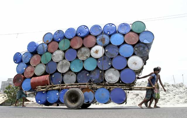 Bangladeshi labourers pull a cart of used containers to the market in Dhaka April 26, 2007. (Photo by Rafiqur Rahman/Reuters)