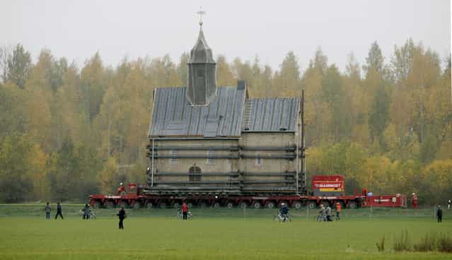 The Emmaus church is transported on a special trailer, after leaving the eastern German village of Heuersdorf October 25, 2007. The church, built in 1297, will be moved over 12 kilometres to the neighbouring town of Borna, as Heuersdorf has to give way for the extension of an opencast lignite mine. (Photo by Arnd Wiegmann/Reuters)
