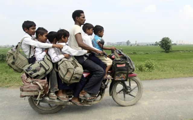 A man rides a motorcycle carrying six children on their way back home from school at Greater Noida in the northern Indian state of Uttar Pradesh September 10, 2010. (Photo by Parivartan Sharma/Reuters)