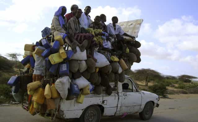 Residents ride on a pick-up truck that supplies milk and other items in Somalia's capital Mogadishu, September 2, 2009. (Photo by Omar Faruk/Reuters)