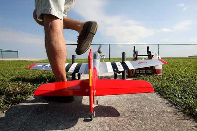 Dusty Rhoads of Jupiter steps over his P51 remote control plane. (Photo by Bill Ingram/The Palm Beach Post)