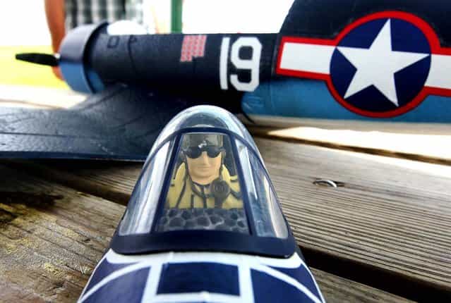 A WWII pilot rests in the removable cockpit of a remote control plane at Phil Wherry Field. (Photo by Bill Ingram/The Palm Beach Post)