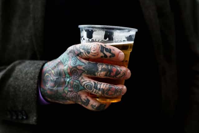 A tattooed man holds a beer. (Photo by Stefan Wermuth/Reuters)